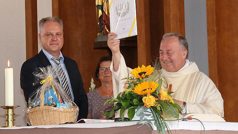 Ein Geschenk und eine Ehrenurkunde Überreichte der Sprecher der Kirchenverwaltung, Christian Höfler (links), an Domkapitular Professor Dr. Tadeusz Koslowski (rechts), der in Nüdlingen sein 40. Priesterjubiläum feierte.       -  Ein Geschenk und eine Ehrenurkunde Überreichte der Sprecher der Kirchenverwaltung, Christian Höfler (links), an Domkapitular Professor Dr. Tadeusz Koslowski (rechts), der in Nüdlingen sein 40. Priesterjubiläum feierte.