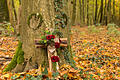 Cross in front of tree trunk in the forest       -  Bestattungen in einem natürlichen Umfeld werden beliebter.