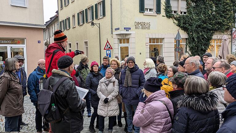 Gerhard Rauscher (erhöht) und Norbert Lenhard (daneben) erklären die Bedeutung der Judengasse. Seit dem Mittelalter verweist der Name der Straße auf die dortigen Wohngebäude, die Juden zugewiesen wurden. Juden wurden seit aus der Stadtbevölkerung ausgegrenzt und durften daher nur bestimmte Gebiete bewohnen. Teilweise waren das Ghettos, die den Jüdinnen und Juden nur sehr niedrige Lebensstandards boten.