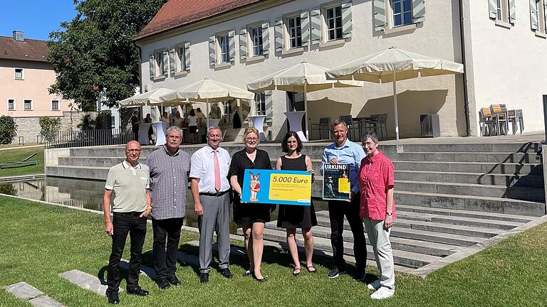 Übergabe des Kinderbibliothekspreises (von links): Günter Jira (Bayernwerk Kommunalbetreuer), Diakon Werner Trenkamp, Bürgermeister Roland Schmitt, Dr. Claudia Pecher (Leiterin der Landesfachstelle für Büchereien und Bildung, Sankt Michaelsbund), Corina Kölln (Leiterin der Bücherei im Wasserschloss), Bernd Göttlicher (Bayernwerk Bereichsleiter Kommunen und Kooperationen Region Franken) sowie Almut Koschel (Leiterin kath. Büchereifachstelle Diözese Würzburg).