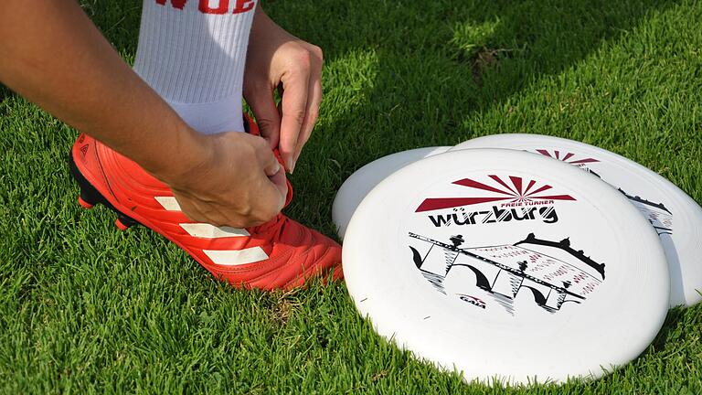 Nur 175 Gramm wiegt das Sportgerät, die Frisbeescheibe. Für einen besseren Grip wird auf dem Rasen mit Stollenschuhen gespielt. Nur 175 Gramm wiegt das Sportgerät, die Frisbeescheibe. Für einen besseren Grip wird auf dem Rasen mit Stollenschuhen gespielt.