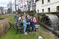 Paul Bruckmann zeigt den Geiselwinder Kommunionkindern das Mühlrad der historischen Kunstmühle Lonnerstadt.