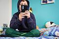 Kind hält Smartphone in den Händen       -  Echt oder Fake? Das können Kinder oft nicht leicht erkennen. Eltern sollten daher ihr Kind dazu ermutigen, Medien kritisch zu hinterfragen.