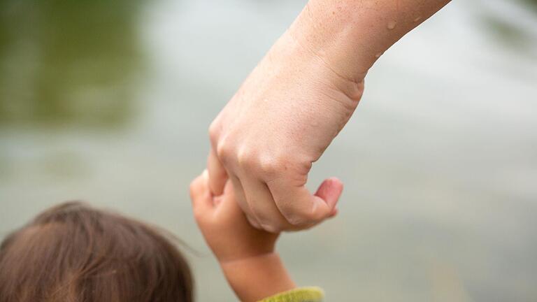 Mutter hält Kind an der Hand.jpeg       -  Schwierige Vater-Kind-Beziehungen können das Leben nachhaltig prägen