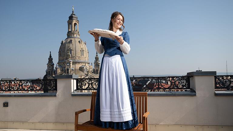 Vorstellung des 30. Dresdner Stollenmädchens       -  Das 30. Dresdner Stollenmädchen mit einem der berühmten Striezel vor der Frauenkirche