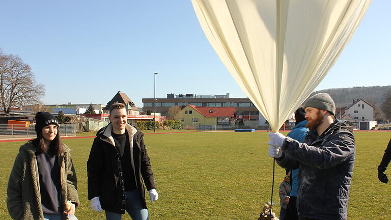 Selina Biyik (von links) und Niklas Hanft zusammen mit Studienrat Johannes Krönung kurz vor dem Start des Wetterballons.