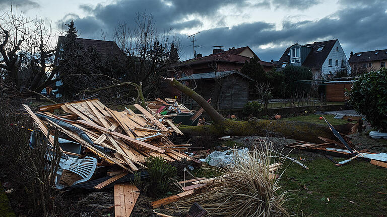 Tornado in Kürnach - Tag danach       -  Eine völlig zerstörte Gartenhütte und ein entwurzelter Baum sind am 10.03.2017 bei Morgendämmerung in einem Garten in Kürnach (Bayern) zu sehen. Eine Windhose, auch als Tornado bezeichnet, hatte am Vortag erhebliche Schäden in der unterfränkischen Ortschaft angerichtet. Zahlreiche Häuser und Lauben waren durch den Sturm zu Schaden gekommen. Verletzt wurde niemand.