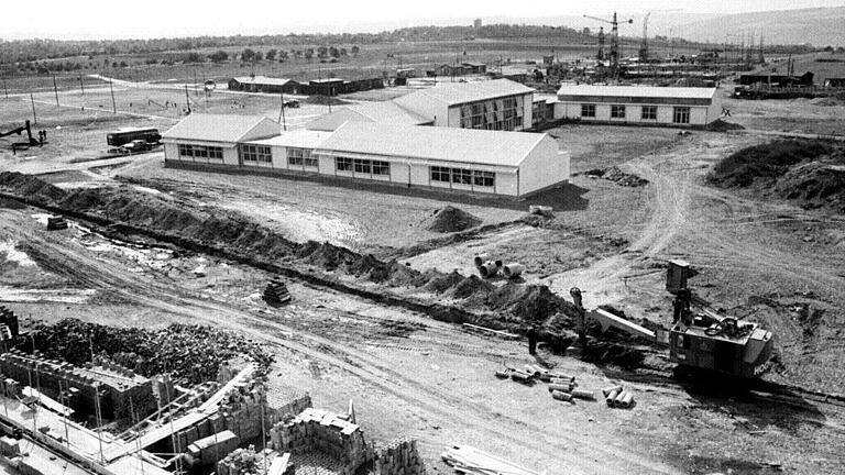 Die Kamera blickt 1951 in südwestlicher Richtung über einen kleinen Teil des weitläufigen Baugeländes des neuen amerikanischen Wohngebietes &bdquo;Skyline Hill&ldquo;. In der Bildmitte steht die amerikanische Grundschule, davor und dahinter wühlen Baumaschinen im Boden. In der Ferne ist der Wasserturm im Sieboldswäldchen zu erkennen. Archivfoto: Walter Röder