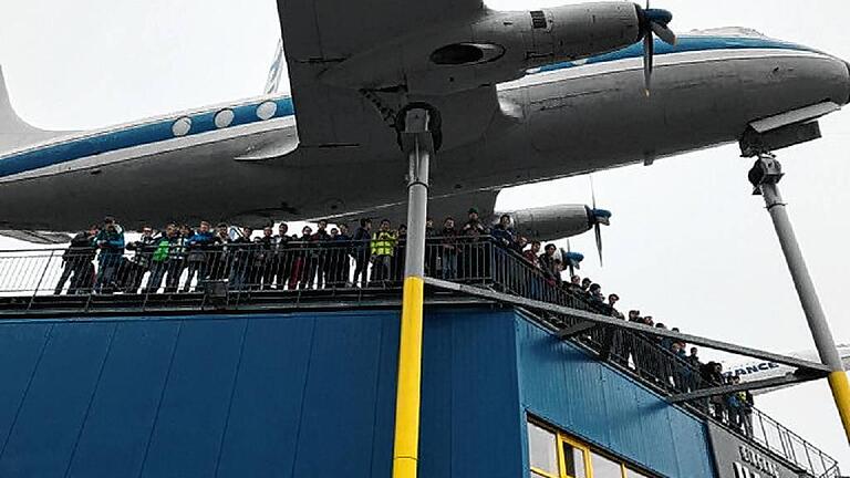 Die Realschüler unter den Tragflächen eines Flugzeugs.