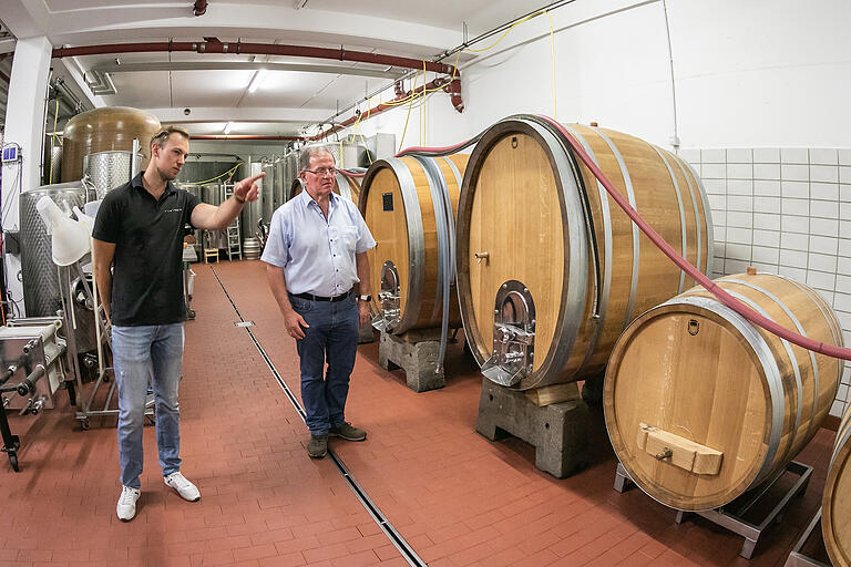 Im Holzfasskeller des Weingut Leininger in Eibelstadt gibt Florian Engelmann Bezirkstagspräsidenten Erwin Dotzel Einblicke in die Weinverarbeitung. Im Holzfasskeller des Weingut Leininger in Eibelstadt gibt Florian Engelmann Bezirkstagspräsidenten Erwin Dotzel Einblicke in die Weinverarbeitung.