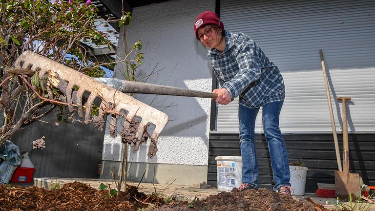 Lena Halbig recht Bienenweide-Samen in die Erde. Sie zieht das Saatgut teils selbst und bietet es in ihrem 'Kästla' zum Tausch an.  Foto: Ronald Rinklef       -  Lena Halbig recht Bienenweide-Samen in die Erde. Sie zieht das Saatgut teils selbst und bietet es in ihrem 'Kästla' zum Tausch an.  Foto: Ronald Rinklef