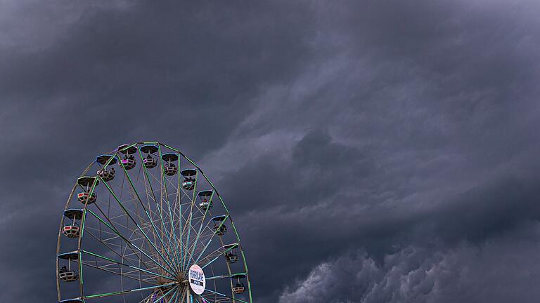 Regenwolken       -  Dunkle Regenwolken ziehen über ein Riesenrad auf dem Gelände des Hurricane-Festivals in Scheeßel hinweg.