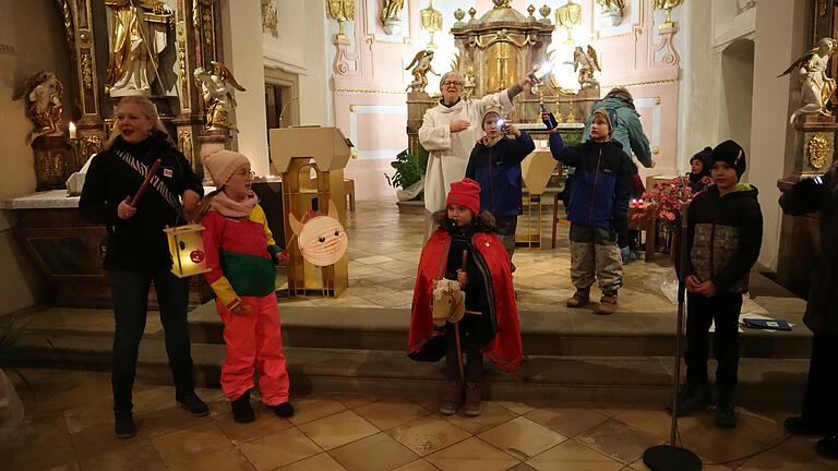 Die Kinder gestalten die Wort-Gottes-Feier zum Martinstag in der Kirche St. Aegidius mit. Im Vordergrund ein Kind, das den Heiligen Martin auf seinem Pferd darstellt, der seinen Mantel teilt.