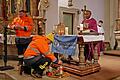 Christian Kraft, der Vorstand der Freiwilligen Feuerwehr Hausen, entzündet das Friedenslicht aus Betlehem in die Hausener Kirche. Von hier aus kann es mit heim genommen werden. Links André Ziegler, rechts Father Dunstan Asiimwe.