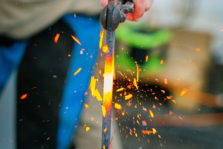 Der Flachstahl wird mit einem Hammer von oben gestaucht. Dadurch wird die Mitte breiter. Der Flachstahl wird mit einem Hammer von oben gestaucht. Dadurch wird die Mitte breiter. 