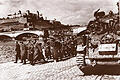 Deutsche Soldaten gehen in Gefangenschaft. Im Hintergrund die notdürftig reparierte Löwenbrücke.