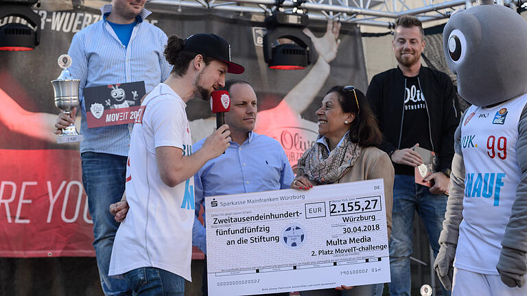 'Move It', Abschlussaktion mit s.Oliver Würzburg - Vertreter der s. Oliver Baskets ehrten am Montag (30.04.18) vor der s. Oliver Arena in Würzburg Sieger und Teilnehmer der Move-it-Challenge. Über einen Spendenscheck vom Zweitplatzierten Multa Medio freute sich Gaby Nelkenstock für ihre Stiftung 'Forschung hilft'. 'Move It', Abschlussaktion mit s.Oliver Würzburg - Vertreter der s. Oliver Baskets ehrten am Montag (30.04.18) vor der s. Oliver Arena in Würzburg Sieger und Teilnehmer der Move-it-Challenge. Über einen Spendenscheck vom Zweitplatzierten Multa Medio freute sich Gaby Nelkenstock für ihre Stiftung 'Forschung hilft'.