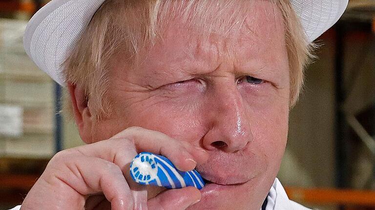 TOPSHOT-BRITAIN-POLITICS-EU-BREXIT-VOTE-CONSERVATIVE       -  Premier Boris Johnson als Wahlkämpfer: Bei einem Firmenbesuch probiert er eine Zuckerstange.