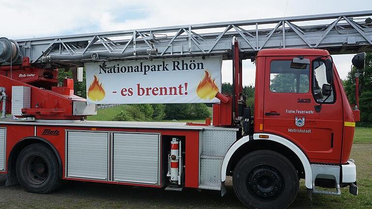 Das ehemalige Fahrzeug der Feuerwehr Mellrichstadt wurde am 30. Mai bei einer Demo gegen den Nationalpark Rhön dekorativ aufgestellt. Dumm nur, dass die Hoheitszeichen der Stadt noch verbotenerweise am Fahrzeug angebracht sind. Bis Ende der Woche sollen diese entfernt werden, sonst droht dem einstigen Käufer Ärger.