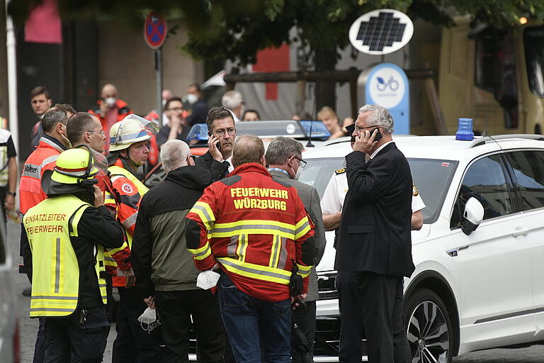 Oberbürgermeister Christian Schuchardt (mit Telefon links) und Innenminister Joachim Herrmann (rechts mit Telefon) machen sich ein Bild vor Ort am Barbarossaplatz.