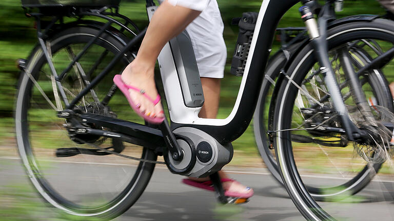 E-Bike       -  Symbolbild: Eine Radfahrerin fährt mit einem E-Bike.