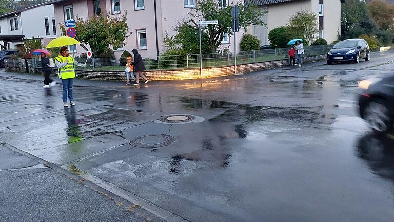 Bei Regen sind Fußgänger, vor allem Kinder, für Autofahrer kaum zu sehen. Schulweghelfer nahe der Friedrich-Fleischmann-Grundschule Marktheidenfeld sorgen dafür, dass Kinder die Straße sicher überqueren können.