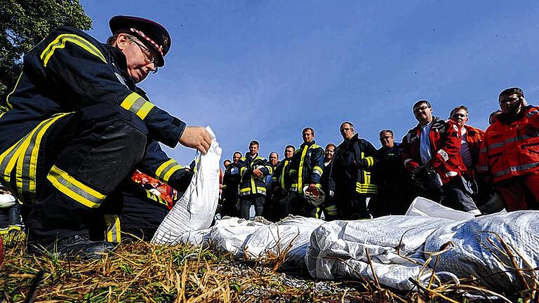 Könnte im Ernstfall Leben retten: Einsatzkräfte verschiedener Feuerwehren bekamen am Samstag in einem Kieswerk bei der Katastrophenschutzübung &bdquo;Rheinflut 2012&ldquo; erklärt, wie man einen Damm aus Sandsäcken errichtet.