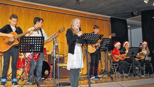 Christmas-Earth-Song: Die Gitarrenband, hier mit Sängerin Maria Bauer, spielte beim Weihnachtskonzert im Gymnasium Bad Königshofen besinnliche Popsongs.