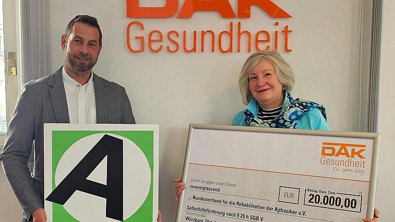 Einen Scheck über 20.000 Euro übergab David Hupp (Leiter Servicezentrum DAK-Gesundheit Würzburg) an Dagmar Amslinger (Geschäftsführerin des Bundesverbandes der Aphasiker).