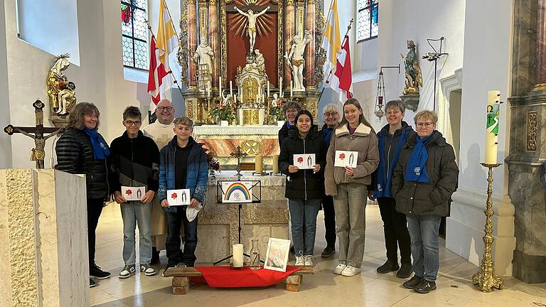 Das Vorstandsteam des Katholischen Deutschen Frauenbundes und die Firmlinge, die den Jubiläums-Gottesdienst mitgestaltet hatten, stellen sich für das Erinnerungsfoto dem Fotografen. Mit im Bild: Pfarrer Andreas Engert.