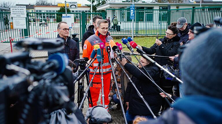 Kai Kranich, Pressesprecher des Deutschen Roten Kreuzes, spricht vor der Südpfalz-Kaserne bei einer Pressekonferenz mit Journalisten. In der Kaserne werden die Personen aus China, die aus der stark vom Coronavirus betroffenen Stadt Wuhan kamen, in Quarantäne gehalten. Kai Kranich, Pressesprecher des Deutschen Roten Kreuzes, spricht vor der Südpfalz-Kaserne bei einer Pressekonferenz mit Journalisten. In der Kaserne werden die Personen aus China, die aus der stark vom Coronavirus betroffenen Stadt Wuhan kamen, in Quarantäne gehalten.