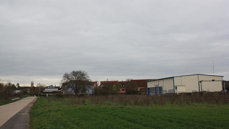 Auf der Freifläche am nördlichen Stadtrand von Gerolzhofen (Bildmitte) plant die Feuerwehr Gerolzhofen die Einrichtung eines Übungsplatzes. Der Betonweg (links im Bild) führt in Richtung Kläranlage und Kompostanlage. Die Halle rechts im Bild ist die frühere Unterkunft des THW.