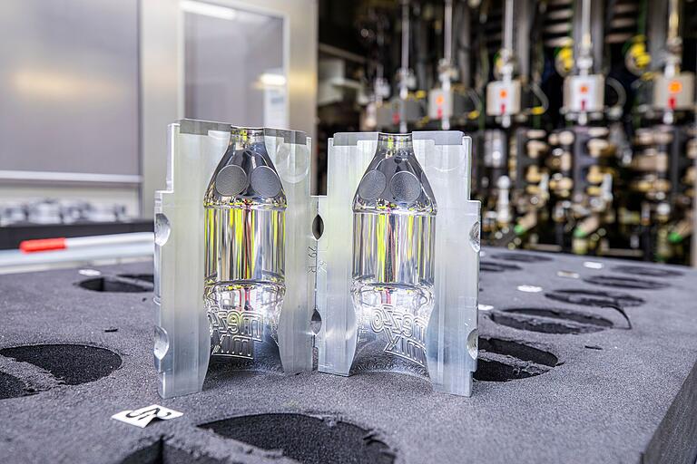 Im Knetzgauer Werk wird nicht nur die bekannte Coca-Cola produziert - sondern auch weitere Getränkesorten. In der modernsten Produktionslinie werden die Flaschenrohlinge in solchen Formen aufgeblasen. Im Knetzgauer Werk wird nicht nur die bekannte Coca-Cola produziert - sondern auch weitere Getränkesorten. In der modernsten Produktionslinie werden die Flaschenrohlinge in solchen Formen aufgeblasen. 