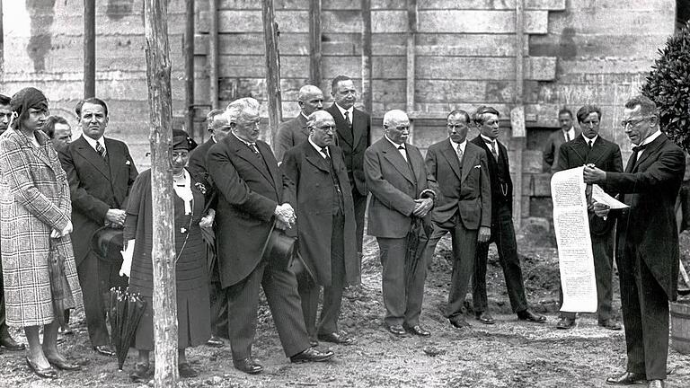 Grundsteinlegung für das Ernst-Sachs-Bad:  Oberbürgermeister Benno Merkle (rechts) verliest die Urkunde, die eingemauert wird. Von links: Elinor und Willy Sachs, Betti und Ernst Sachs, Architekt Lehrmann, dahinter die Bauunternehmer Adam Tasch und Michael Siebenson, Stadtrat Leonhard Riedel, Architekt Kiesel, Oberbaurat Zierl und Architekt Roderich Fick.