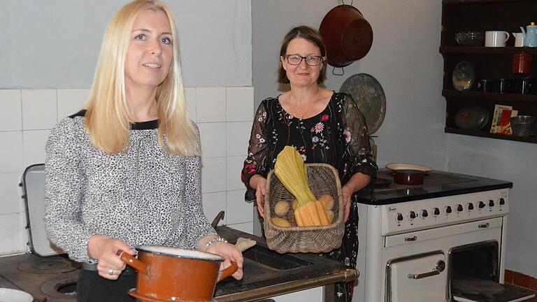 In der Schlossküche sieht es so aus, als ob gerade lecker gekocht wird. Josefine Glöckner, Leiterin der Aschacher Schlossmuseen (links) und Dr. Birgit Speckle, wissenschaftlicher Mitarbeiterin des Bezirks Unterfranken, zeigen, was auf dem Speisezettel steht.