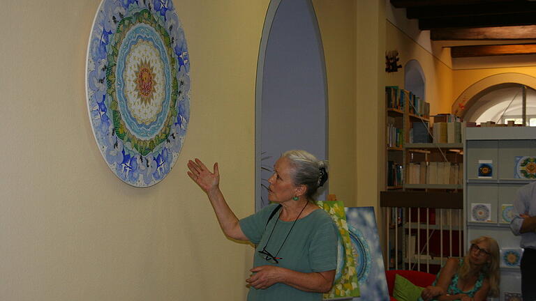 Heike Rose-Tannenberg erläutert eines ihrer Mandalas, die in der Auber Stadtbücherei zur Kirchweih zu sehen sind.&nbsp;