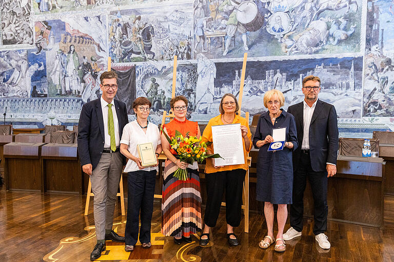 Die Stadt Würzburg verleiht am 21.07.2022 im Rathaus Würzburg Kulturmedaillen: Preisträger:innen sind: Lisa Kuttner, DenkOrt Deportationen und Rollywood e.V. Verleihung der Medaille und Urkunde an DenkOrt Deportationen e.V. – vlnr.: Christian Schuchardt (OB der Stadt Würzburg), Rotraud Ries (Leiterin des Johanna-Stahl-Zentrums für jüdische Geschichte und Kultur in Unterfranken in Würzburg), Christine Hofstetter (2. Vorsitzende), Hannelore Hübner (Schriftführerin), Benita Stolz (1. Vorsitzende und Koordination), Achim Könnecke (Kulturreferent der Stadt Würzburg). Die Stadt Würzburg verleiht am 21.07.2022 im Rathaus Würzburg Kulturmedaillen: Preisträger:innen sind: Lisa Kuttner, DenkOrt Deportationen und Rollywood e.V. Verleihung der Medaille und Urkunde an DenkOrt Deportationen e.V. – vlnr.: Christian Schuchardt (OB der Stadt Würzburg), Rotraud Ries (Leiterin des Johanna-Stahl-Zentrums für jüdische Geschichte und Kultur in Unterfranken in Würzburg), Christine Hofstetter (2. Vorsitzende), Hannelore Hübner (Schriftführerin), Benita Stolz (1. Vorsitzende und Koordination), Achim Könnecke (Kulturreferent der Stadt Würzburg).