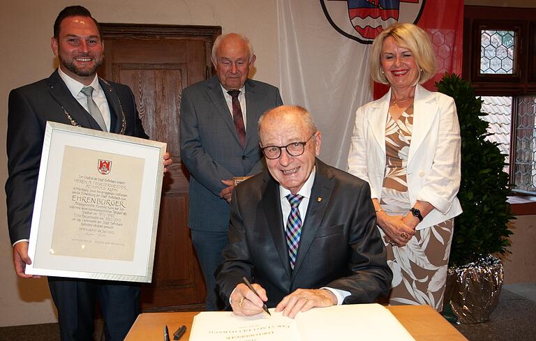 Ehrenbürger Reinhold Kuhn trägt sich ins goldene Buch der Stadt Dettelbach ein, flankiert von Bürgermeister Matthias Bielek, Günther Beckstein und Landrätin Tamara Bischof. Ehrenbürger Reinhold Kuhn trägt sich ins goldene Buch der Stadt Dettelbach ein, flankiert von Bürgermeister Matthias Bielek, Günther Beckstein und Landrätin Tamara Bischof.