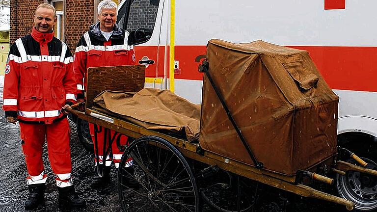 Wetterfest: Die Rettungsassistenten Ralf Krotky und Hans Wagner (von links) mit der fahrbaren Trage aus der Gründerzeit.