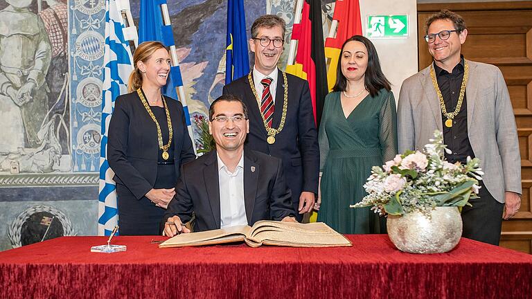 Der Präsident des rumänischen Fußballverbands Razvan Burleanu trägt sich ins Goldene Buch der Stadt Würzburg ein. Mit dabei: v. l. Bürgermeisterin Judith Roth-Jörg, OB Chistian Schuchardt, Generalkonsulin Miheia-Mălina Diculescu-Blebea und Bürgermeister Martin Heilig.