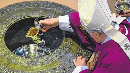 Bischof Friedhelm Hofmann schöpft zu Beginn des Gottesdienstes Weihwasser aus dem Taufbecken. Bischof Friedhelm Hofmann schöpft zu Beginn des Gottesdienstes Weihwasser aus dem Taufbecken.