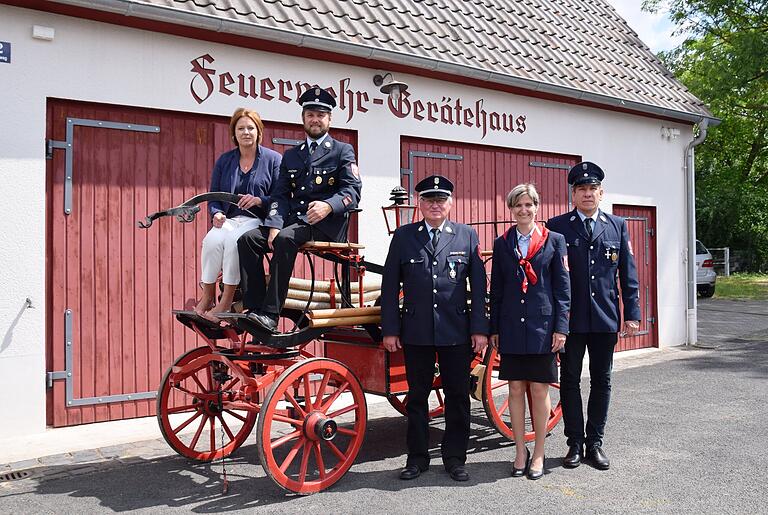 Die alte Feuerspritze ist noch intakt und dient den Verantwortlichen der Freiwilligen Feuerwehr Euerbach als Kulisse: (von links) Bürgermeisterin und Vereinsvorsitzende Simone Seufert, Kommandant Andreas Schraut, Ehrenkommandant Reiner Schraut, Kinderfeuerwehr-Leiterin Susanne Winter und Schriftführer Jörg Winter.