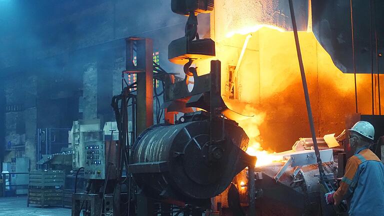 Produktion bei Franken Guss: Flüssiges Eisen wird mit einer Pfanne in den Magnesiumkonverter übergeben. Flüssig wird es nur mithilfe von reichlich Energie. Produktion bei Franken Guss: Flüssiges Eisen wird mit einer Pfanne in den Magnesiumkonverter übergeben. Flüssig wird es nur mithilfe von reichlich Energie.