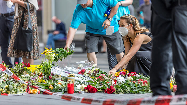 Messerattacke in Würzburg       -  Blick auf den Barbarossaplatz in Würzburg am Samstagmittag (26.06.21) um 13 Uhr. Zahlreiche Menschen entzünden Kerzen und legen vor einem Kaufhaus in der Innenstadt Blumen nieder.