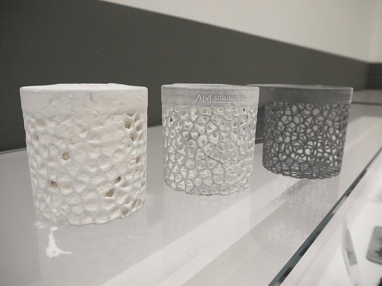 Ein Anschauungsstück von 'AM Solutions' zeigt, warum 3D-gedruckte Bauteile – hier aufgrund von Pulverrückständen – noch nachbearbeitet werden müssen. Ein Anschauungsstück von 'AM Solutions' zeigt, warum 3D-gedruckte Bauteile – hier aufgrund von Pulverrückständen – noch nachbearbeitet werden müssen.
