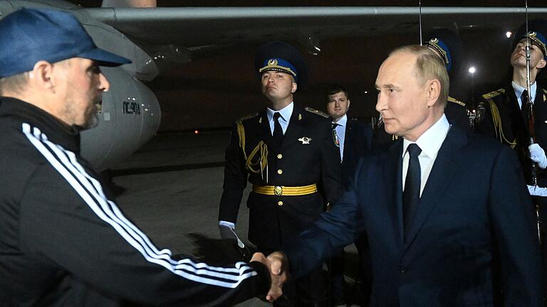 Gefangenenaustausch - russische Gefangene kommen in Moskau an       -  Der verurteilte Mörder Wadim Krassikow (l) wurde am Flughafen von dem russischen Präsidenten Wladimir Putin (r) empfangen.