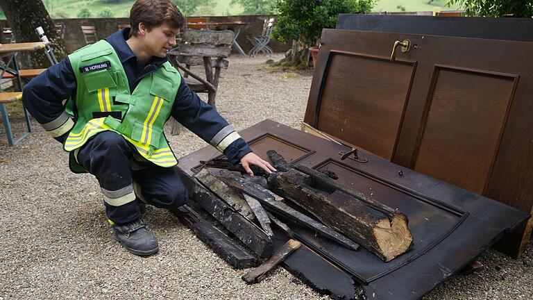 Von den schweren Holzdecken im Gastraum der Hallburg blieben nur verkohlte Überreste, die Moritz Hornung, Pressesprecher der Feuerwehr Volkach, begutachtet.