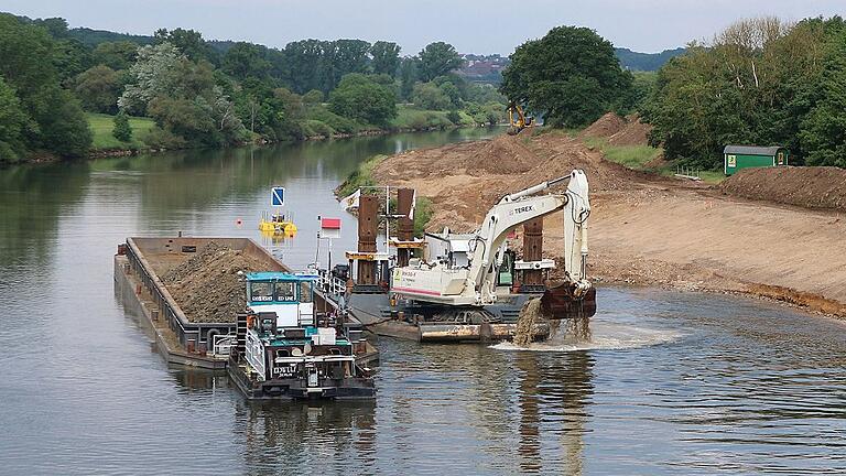 Die Bagger stehen auf Pontons und arbeiten sich vom Wasser aus vorwärts. Das Abbruchmaterial wird auf sogenannte Schuten verladen, die es zum Umschlagplatz nach Grafenrheinfeld transportieren.