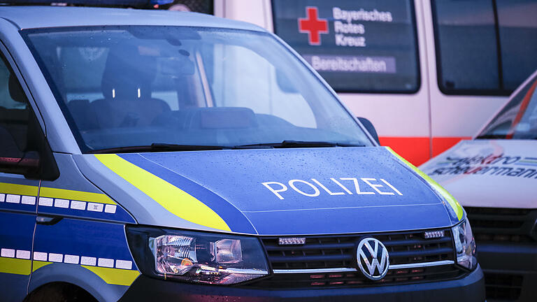 Symbolbild: Polizeiwagen, im Hintergrund BRK-Auto