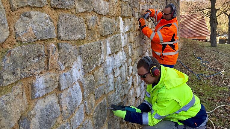 Die Mitarbeiter der Firma Stiel aus Ostheim sind derzeit dabei, schadhafte Fugen an der Stadtmauer im Bereich Hofmannshain zu entfernen.